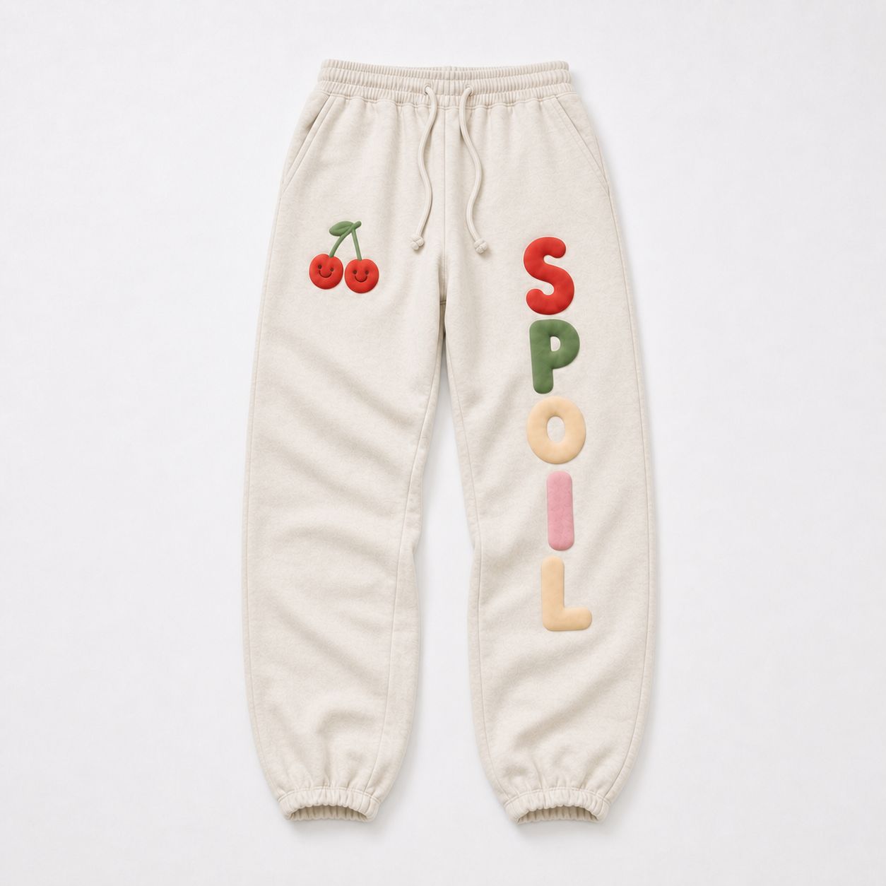 Spoil sweatpants alone, front — smiley cherry pair at the hip, SPOIL stacked down the leg.