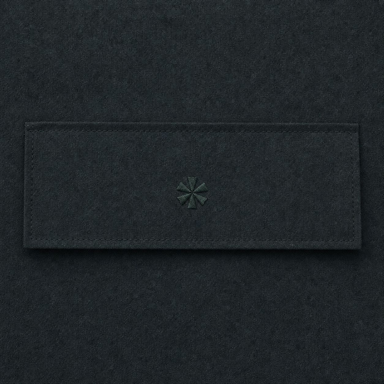 Macro of the tonal kamon crest embroidered on the rear pocket flap of the Zip-Off Cargo Pants