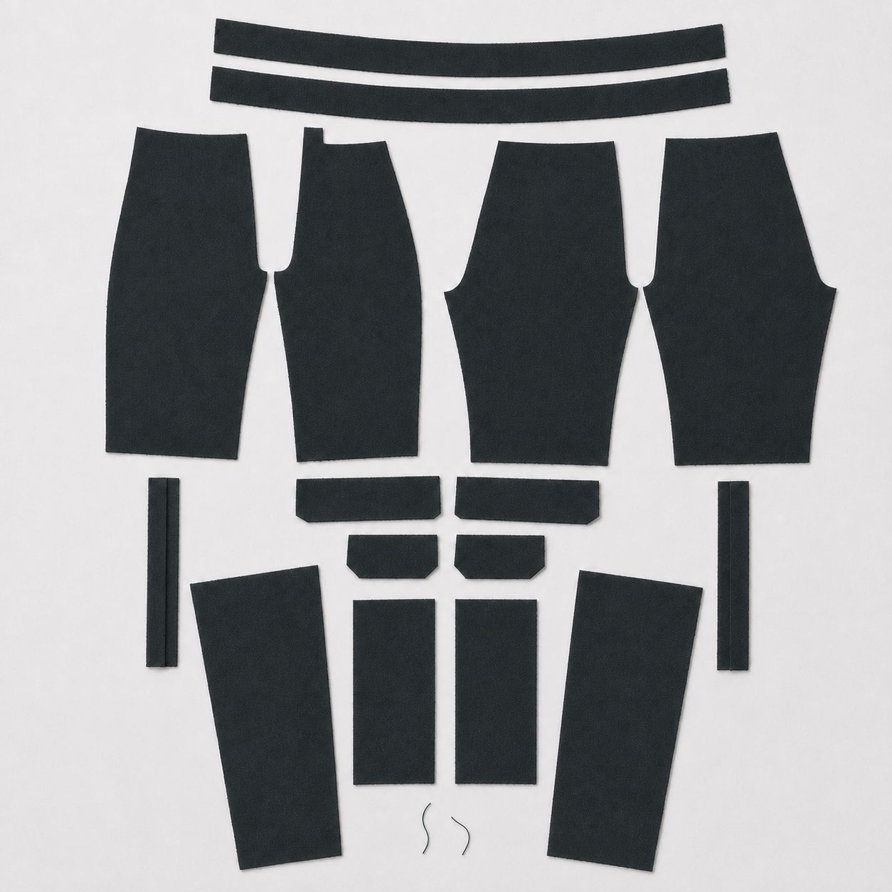 Cut pattern pieces of the vowels Zip-Off Cargo Pants laid out in Dark Forest chambray before assembly