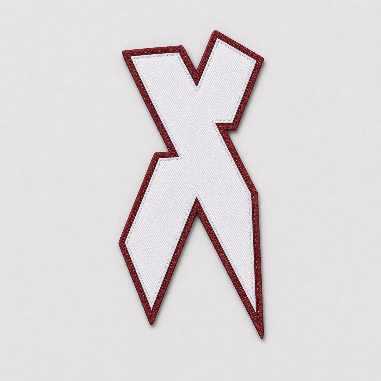 Cut-and-sewn tackle twill X, white on maroon, pre-application.